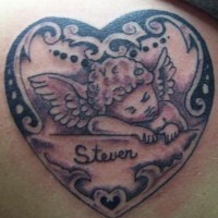 el tatuaje conmemorativo con un bebe angel dentro de un corazon con traceria hecho en color negro