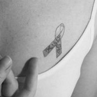 el tatuaje conmemorativo con un simbolo de lucha contra el sida hecho en el pecho