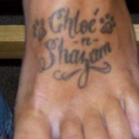 el tatuaje de dos nombres con dos huellas hecho en el pie en color negro