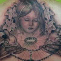 el tatuaje conmemorativo del ertrato de una niña hecho en tinta negra