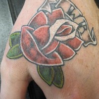 el tatuaje de una rosa con iniciales hecho en color en la mano