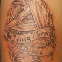 el tatuaje conmemorativo con una lapida, el nombre y la frase 