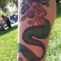 Tatuaggio grande sulla gamba la sirena con la coda verde