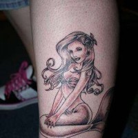 Kleines Tattoo einer Meerjungfrau am Bein