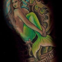 Tatuaggio bellissimo la sirena con la coda verde tra le onde