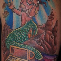 Tatuaggio colorato sul deltoide la sirena sul fondo del mare e il tesoro