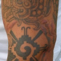 el tatuaje de de un dragon azteca hecho en el brazo con tinta negra y gris