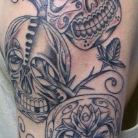 el tatuaje de tres calaveras mexicanas detalladas de color negro hecho en el hombro