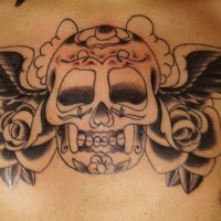 el tatuaje de una calavera con alas y rosas hecho en el pecho en color negro
