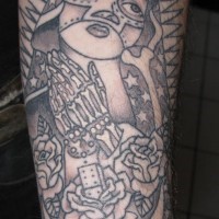 el tatuaje con muchos detalles incluyendo la virgen de guadalupe, manos orantes, el domino, y un luchador de la lucha libre hecho en el brazo