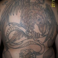 el tatuaje grande de una aguila peleando con una serpiente hecho en toda la espalda