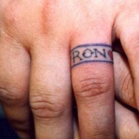 Tattoo eines Rings mit Namen am Finger