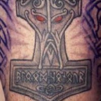 el tatuaje de martillo del thor con una cara y ojos rojos