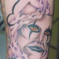 el tatuaje de una mascara con ojos de color naranja y humo alrededor