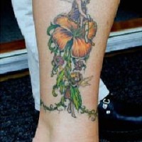 el tatuaje de una hada sobreuna flor hecho en colores en la pierna