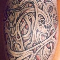el tatuaje de una rotura en la piel con caras de demonios