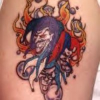 el tatuaje de las caras de comodines en llamas de fuego hecho en color