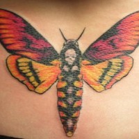 el tatuaje de una palomilla con una calavera hecho en varios colores