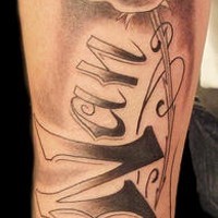 Name and flower memorial tattoo