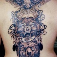 el tatuaje detallado y muy grande del totem con una guila,cabeza del lobo y cabeza de un oso hecho en la espalda