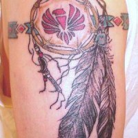 el tatuaje colorado de un talisman con una aguila roja en el centro con plumas en brazalete hecho en el hombro
