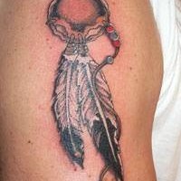 el tatuaje pequeño de un talisman con plumas indianas hecho en el hombro