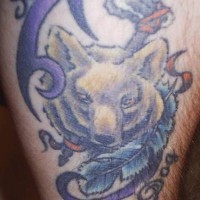 el tatuaje tribal con un lobo y una pluma hecho en colores