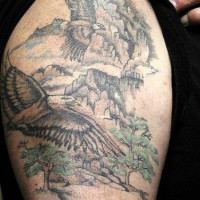 el tatuaje de un paisaje en estilo indigeno hecho parcialmente en color palido