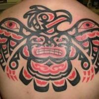 el tatuaje grande de un dios indio en forma de aguila hecho en la espalda en color rojo con negro