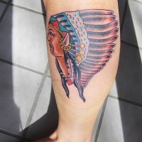el tatuaje de un indio con corona de plumas hecho en colores en la pierna