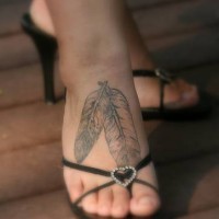 Due piume bianche tatuaggio sul piede