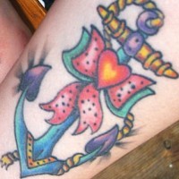 el tatuaje femenino de una ancla con un moño hecho en color