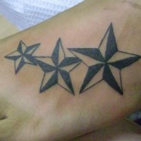 el tatuaje de pie con tres estrellas nauticas de color negro con blanco