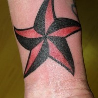 Curved red and black star tattoo on wrist
