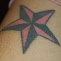 el tatuaje clasico sencillo de una estrella nautica en la muñeca