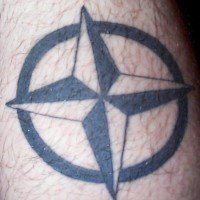 el tatuaje de una estrella nautica con cuatro puntas en un circulo