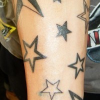 el tatuaje de muchas estrellas hecho con tinta negra en el brazo