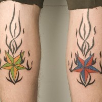 el tatuaje simetrico de etrellas naticas de diferentes colores en las llamas defuego tribal hecho en las piernas