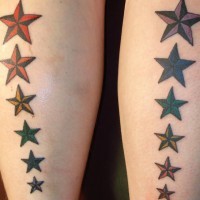 el tatuaje simetrico con dos filas de estrellas nauticas hecho en las piernas