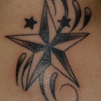 el tatuaje de una estrella nautica negra en las olas de estilo tribal