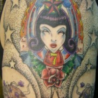 el tatuaje de la mujer vampiro rodeada de estrellas y calaveras hecho en el hombro