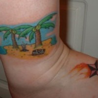 el tatuaje colorado de una isla con plamas y una estrella nautica en el pie