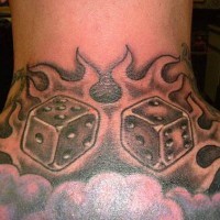 el tatuaje simetrico de dos dados en las llamas de fuego hecho en la espalda en color gris