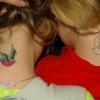 los tatuajes de pareja con dos gorriones uno lineado y otro colorado hechos en las nucas