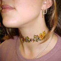 el tatuaje femenino de una traceria floral colorada hecho en el cuello