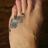 Tattoo mit schwarzer kleiner Orchidee am Fuß