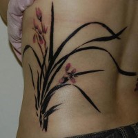 el tatuaje de unas orquideas en sus hojas heco en el costado