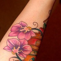 el tatuaje leniado coloradocon orquideas de color morado hecho en la mano