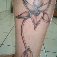 el tatuaje de una orquidea en color gris hecho en la pierna