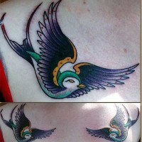Traditional colored tattoo of two birds on scapulas